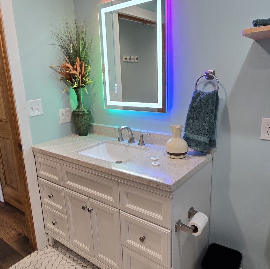 View of bathroom with multicolored backlit mirror and suite entry door for Suite 3 at the London Guest House
